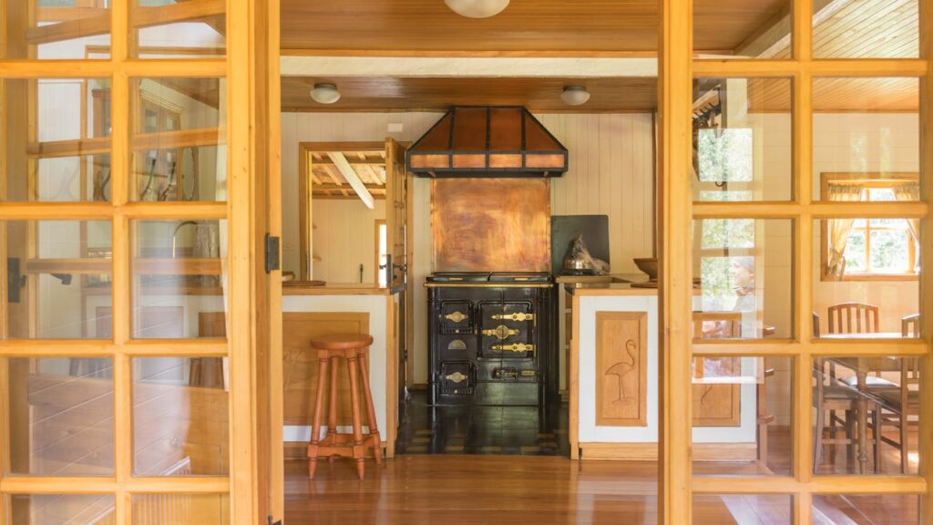 Warm rustic kitchen interior featuring a vintage stove and wooden furniture, offering a glimpse of nostalgic charm.